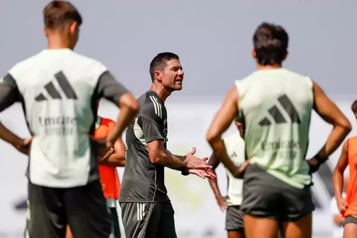Entrenador de fútbol dando indicaciones a sus jugadores durante una práctica al aire libre Entrenador de fútbol dando indicaciones a sus jugadores durante una práctica al aire libre