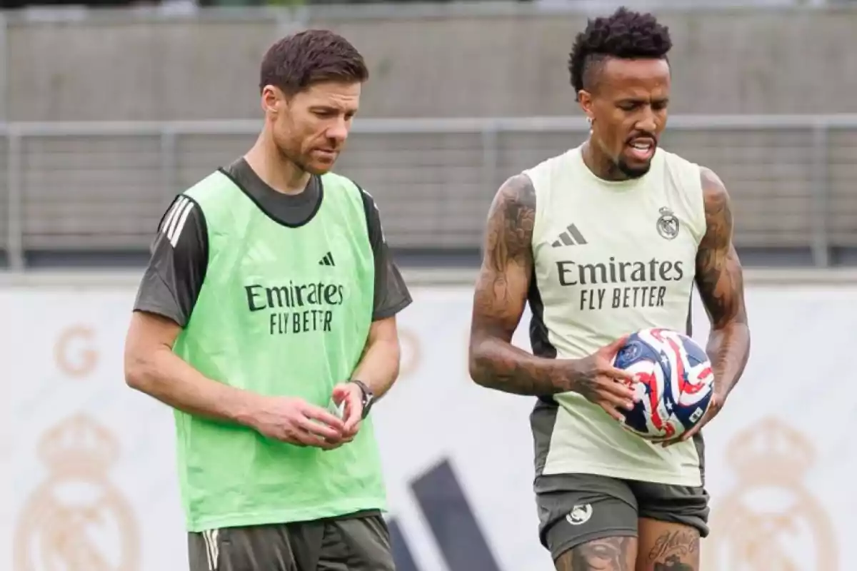 Dos jugadores del Real Madrid entrenando en el campo, uno de ellos sostiene un balón de fútbol americano.