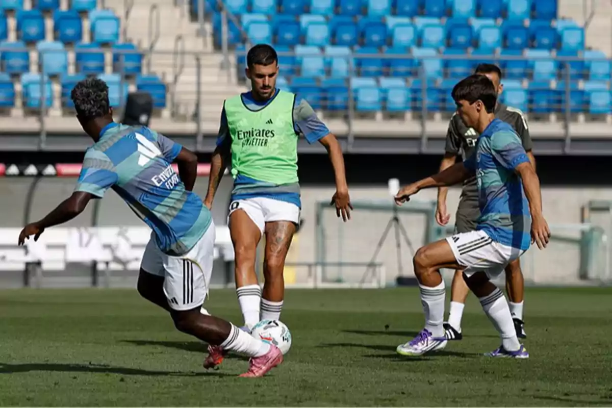 Soccer players training on a field with blue bleachers in the background Soccer players training on a field with blue bleachers in the background