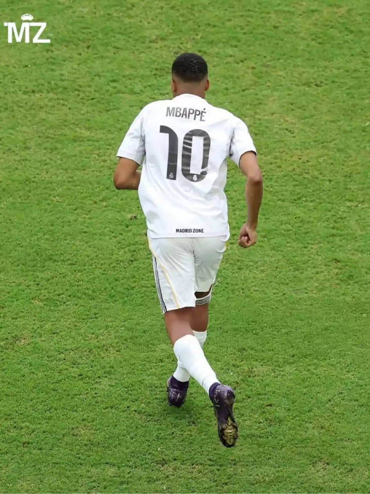Futbolista con el dorsal 10 y el nombre Mbappé en la camiseta blanca corriendo sobre el césped Futbolista con el dorsal 10 y el nombre Mbappé en la camiseta blanca corriendo sobre el césped