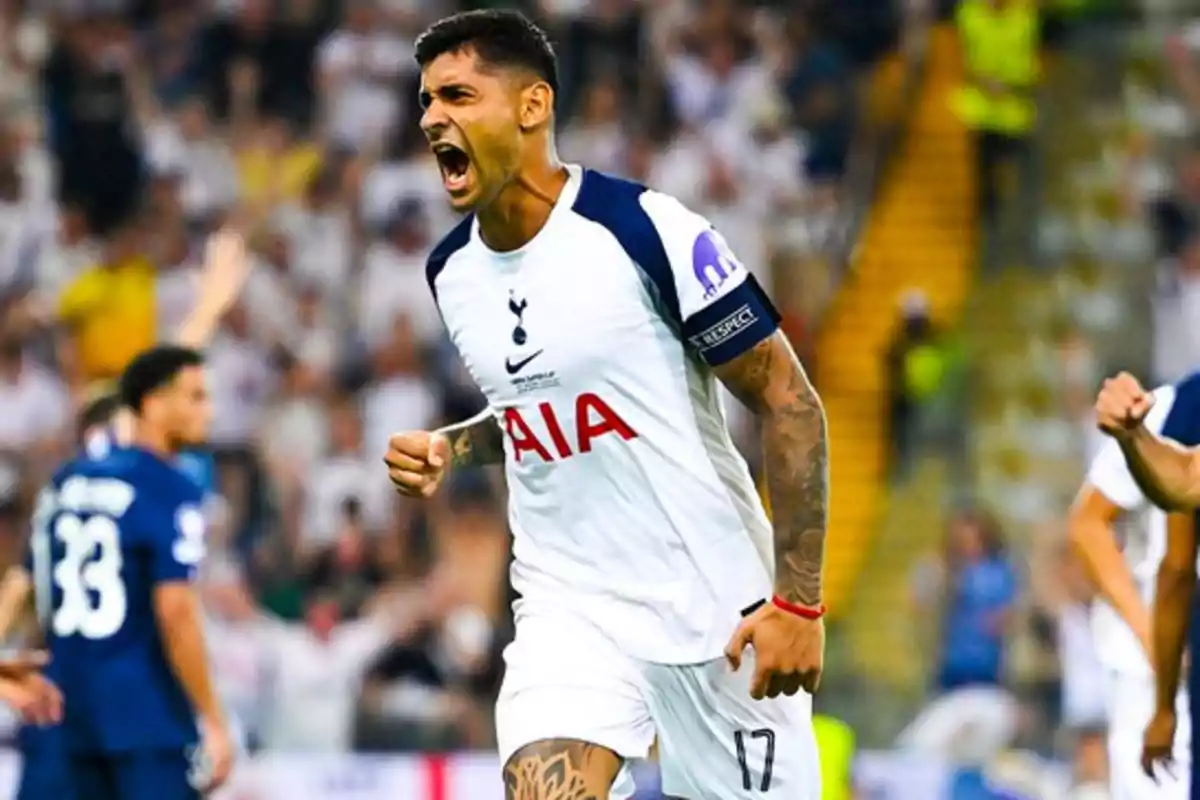 Futbolista del Tottenham celebrando un gol con el puño cerrado y expresión de euforia en un estadio lleno de aficionados Futbolista del Tottenham celebrando un gol con el puño cerrado y expresión de euforia en un estadio lleno de aficionados