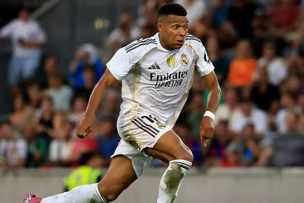 Futbolista con uniforme blanco del Real Madrid corriendo en el campo durante un partido Futbolista con uniforme blanco del Real Madrid corriendo en el campo durante un partido