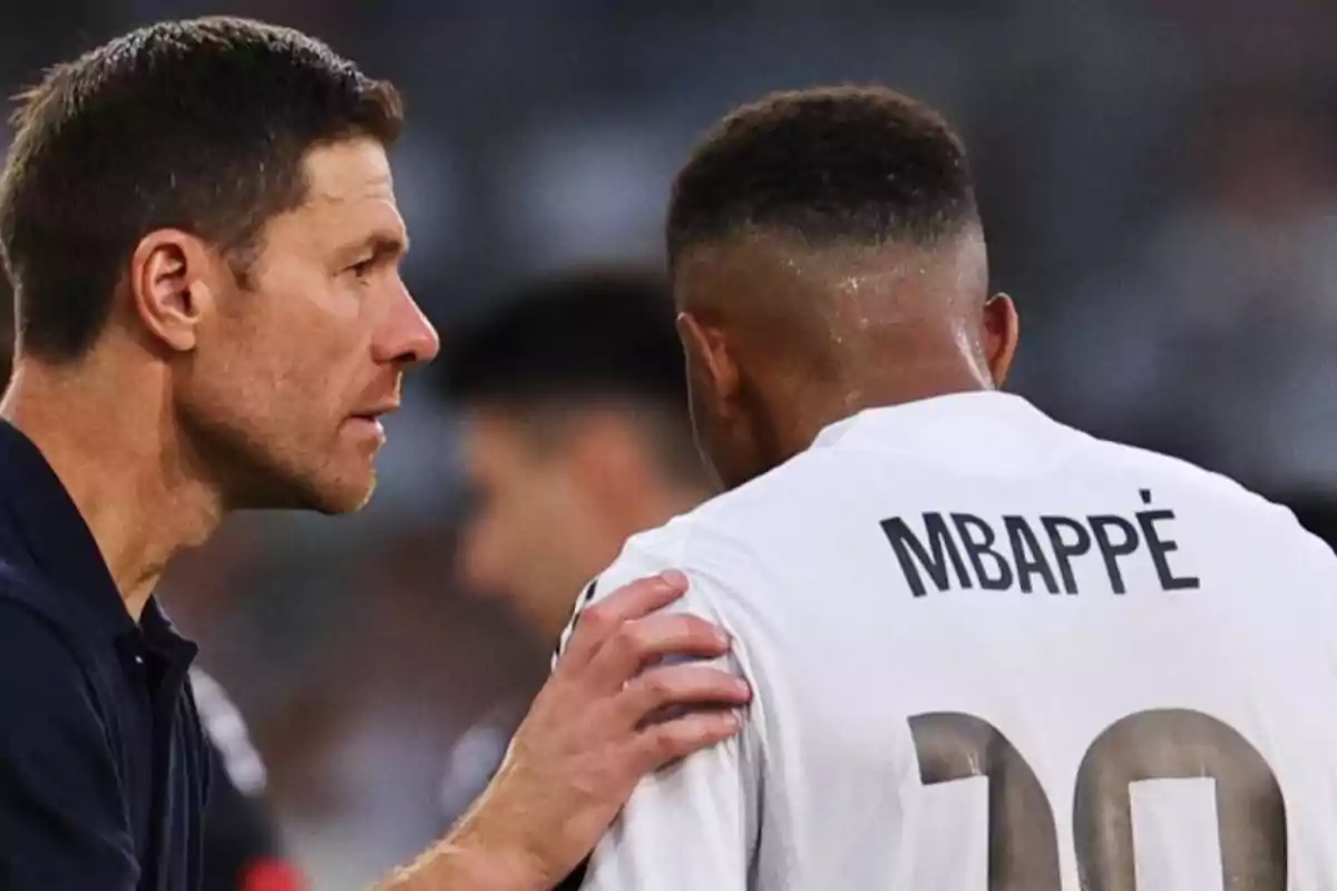 Coach talking to a player wearing a jersey with the name Mbappé.