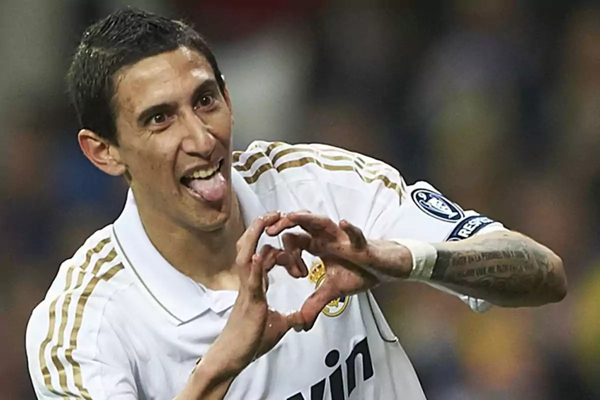 Futbolista con uniforme blanco celebrando un gol haciendo un gesto de corazón con las manos y sacando la lengua Futbolista con uniforme blanco celebrando un gol haciendo un gesto de corazón con las manos y sacando la lengua