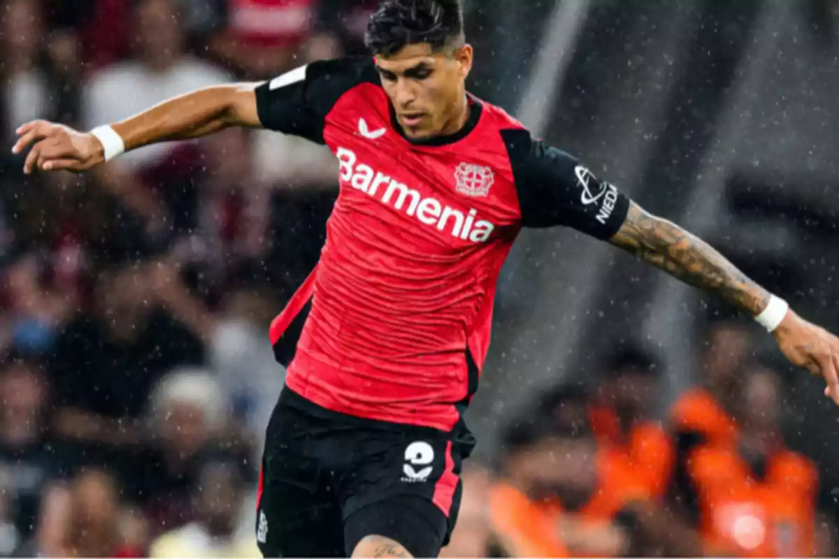 Futbolista del Bayer Leverkusen con uniforme rojo y negro en acción durante un partido Futbolista del Bayer Leverkusen con uniforme rojo y negro en acción durante un partido