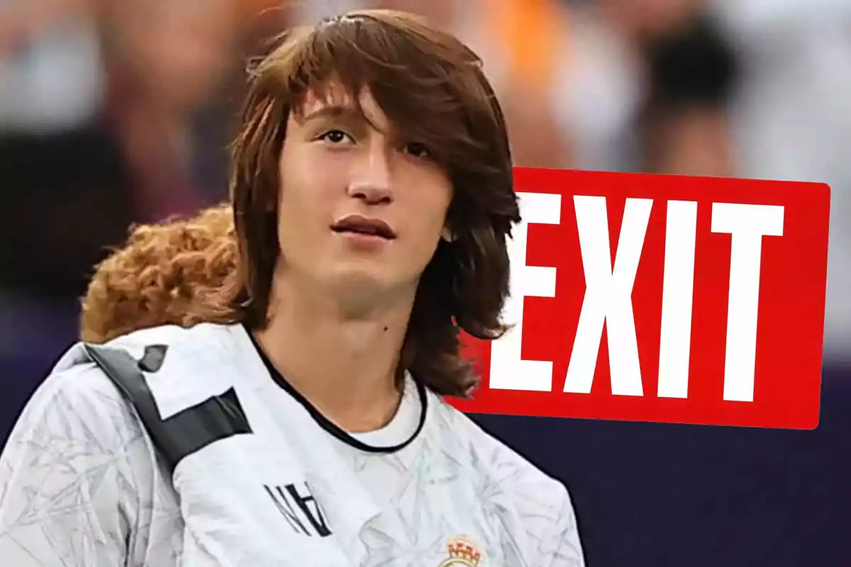 Joven con camiseta deportiva blanca y letrero rojo con la palabra EXIT al fondo