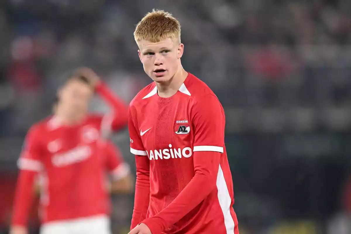 Joven futbolista con uniforme rojo del AZ Alkmaar en el campo durante un partido Joven futbolista con uniforme rojo del AZ Alkmaar en el campo durante un partido