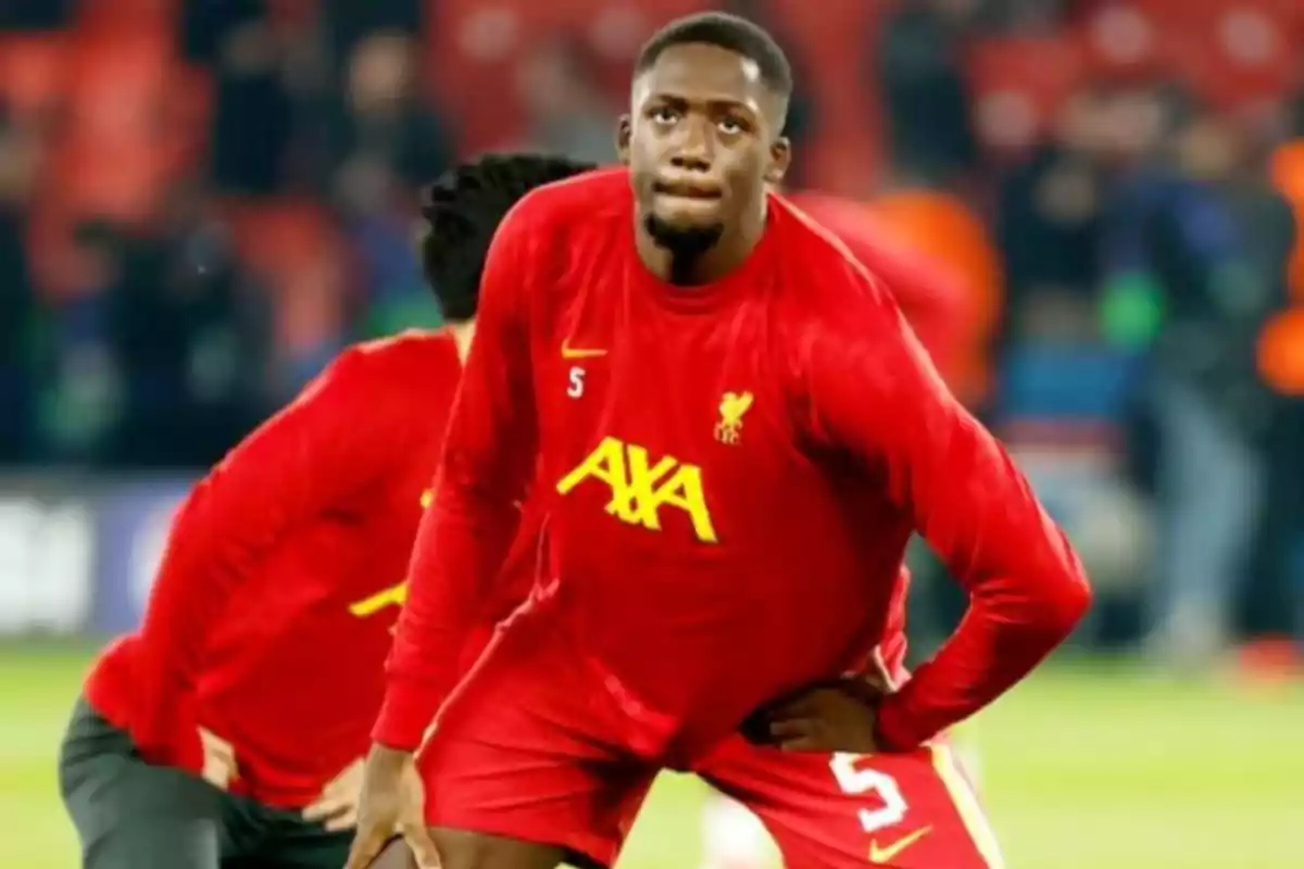 Liverpool footballer in a red uniform warming up on the field before a match Liverpool footballer in a red uniform warming up on the field before a match