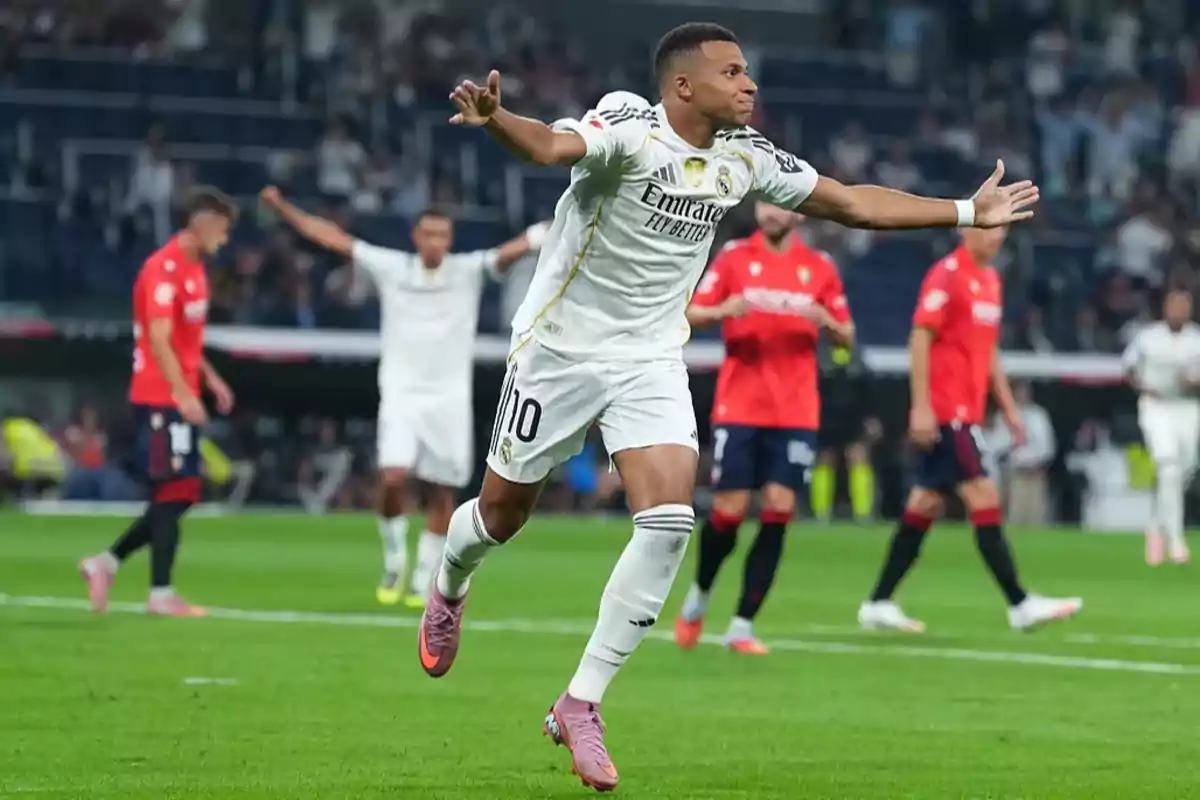 Real Madrid player celebrating a goal with arms outstretched during a match against a team in red uniforms Real Madrid player celebrating a goal with arms outstretched during a match against a team in red uniforms