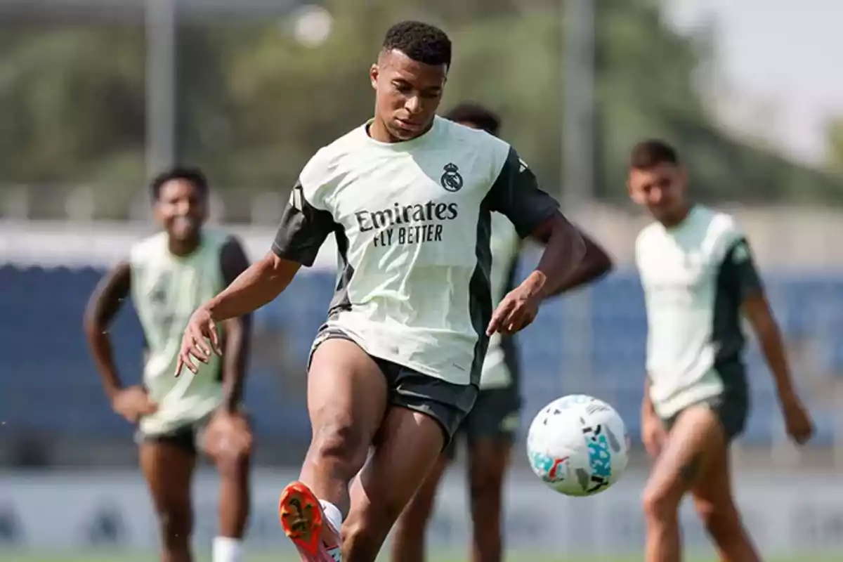 Soccer player training with the ball while other players watch on the training field Soccer player training with the ball while other players watch on the training field