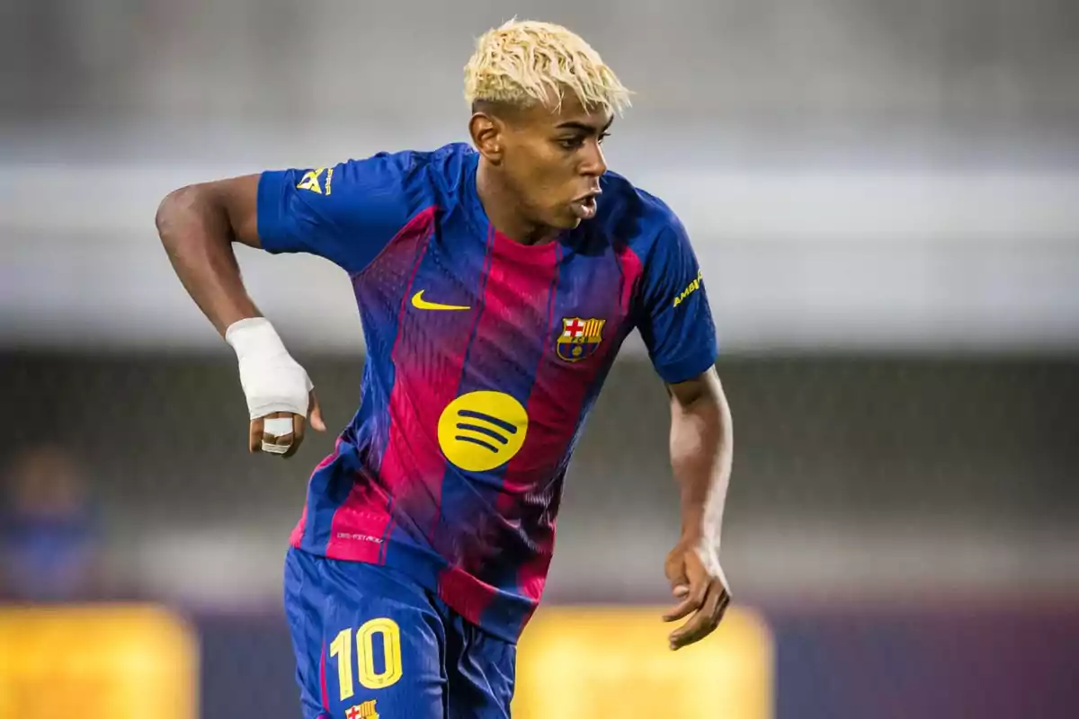 Futbolista con cabello rubio y vendaje en la mano jugando con el uniforme azul y rojo del FC Barcelona