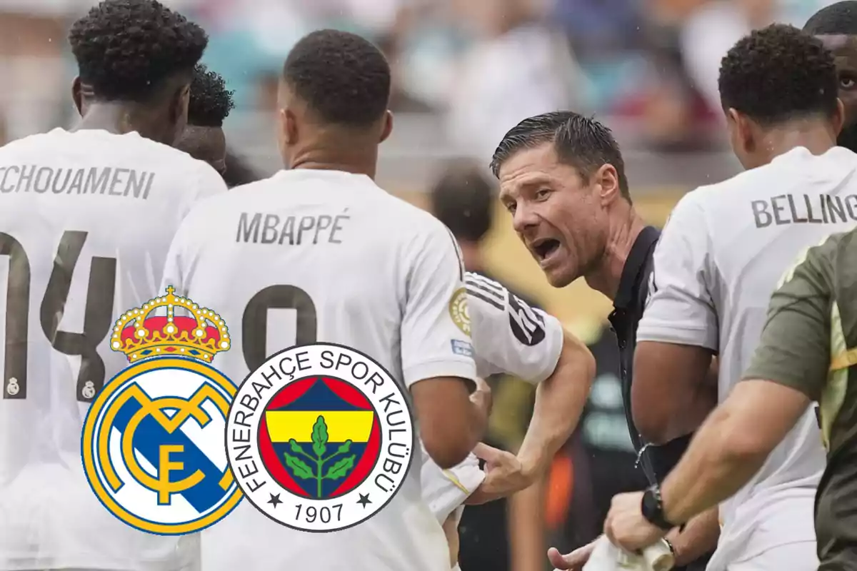 Soccer players in white jerseys listen to their coach while the crests of Real Madrid and Fenerbahce appear in the foreground.