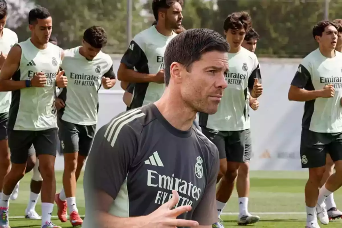 Entrenador de fútbol dando indicaciones mientras jugadores del Real Madrid entrenan en el campo