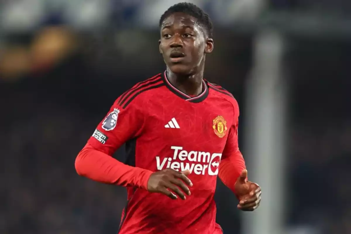 Soccer player in a red Manchester United uniform during a match Soccer player in a red Manchester United uniform during a match