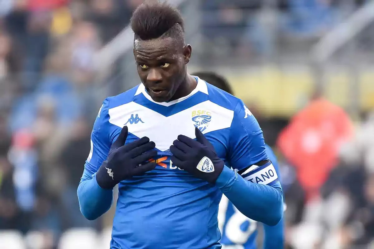 Soccer player in Brescia’s blue and white uniform pointing to his team’s badge during a match