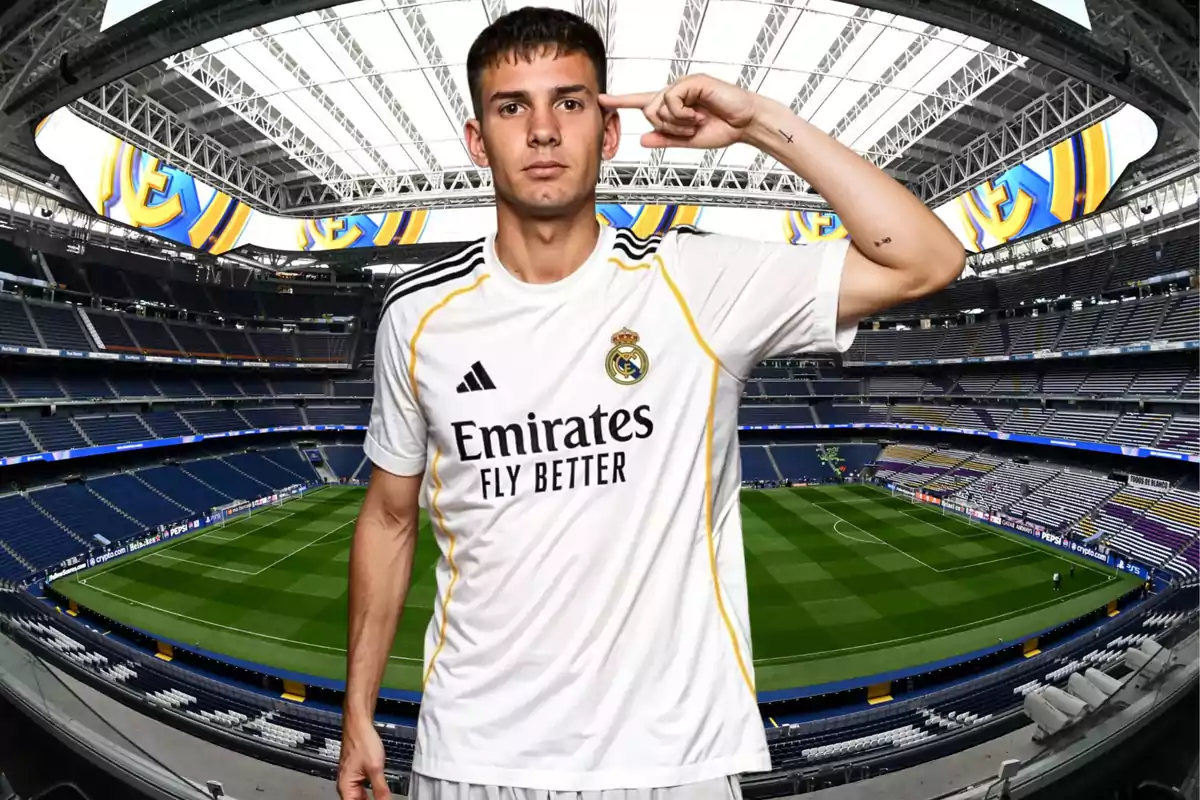 Jugador de fútbol con uniforme blanco del Real Madrid posando en el estadio Santiago Bernabéu