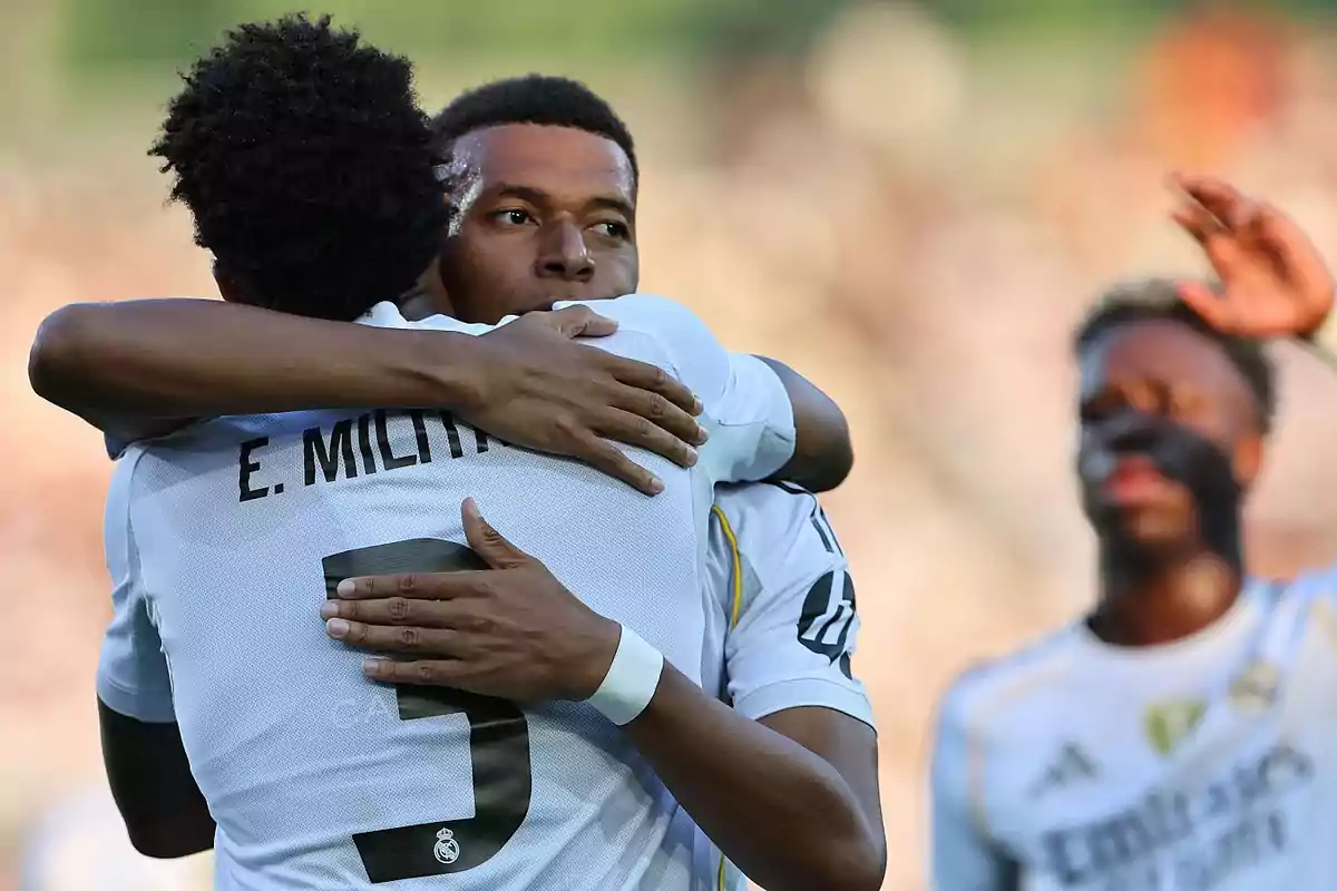 Dos jugadores de fútbol del Real Madrid se abrazan celebrando un gol mientras otro compañero se acerca al fondo Dos jugadores de fútbol del Real Madrid se abrazan celebrando un gol mientras otro compañero se acerca al fondo