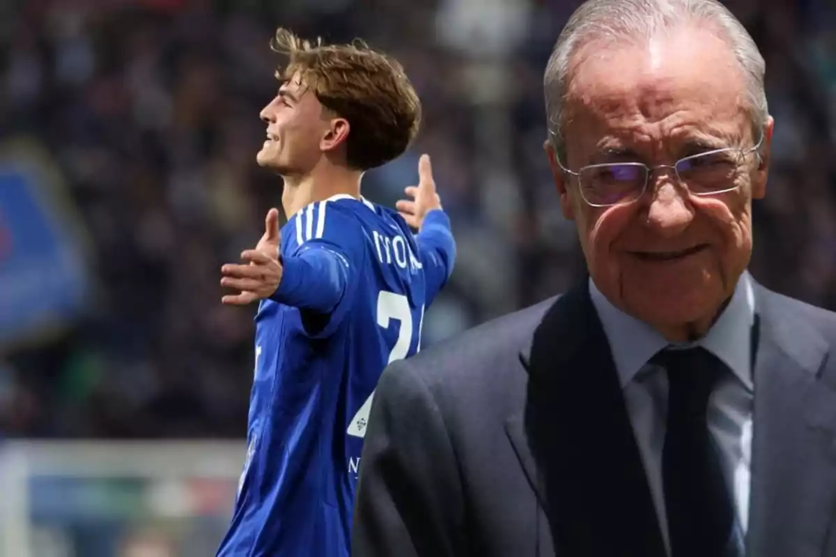 A young player in a blue uniform celebrates with arms outstretched while an older man in glasses and a suit smiles in the foreground.
