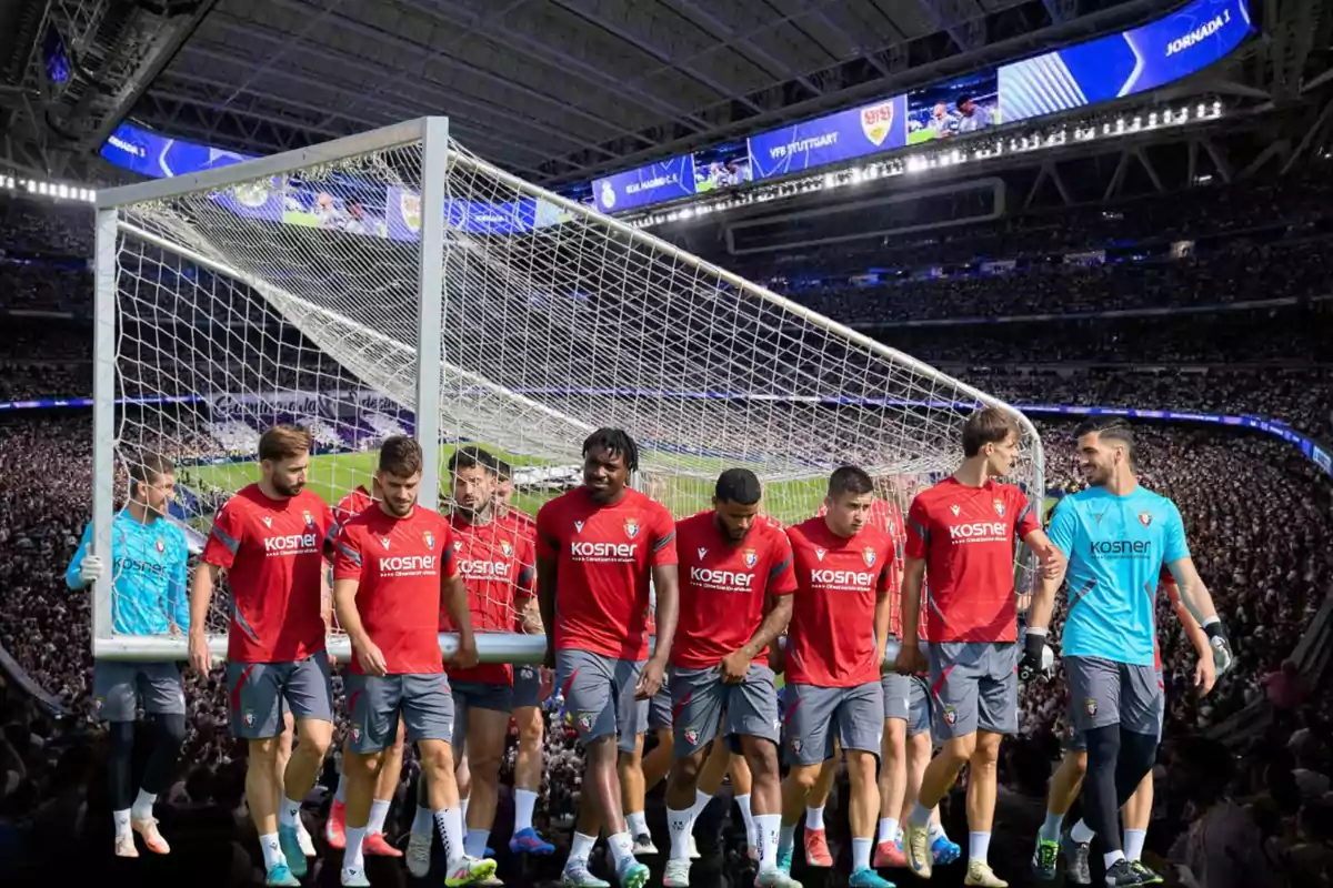 Soccer players in red and blue uniforms carry a goal on a stadium full of spectators.