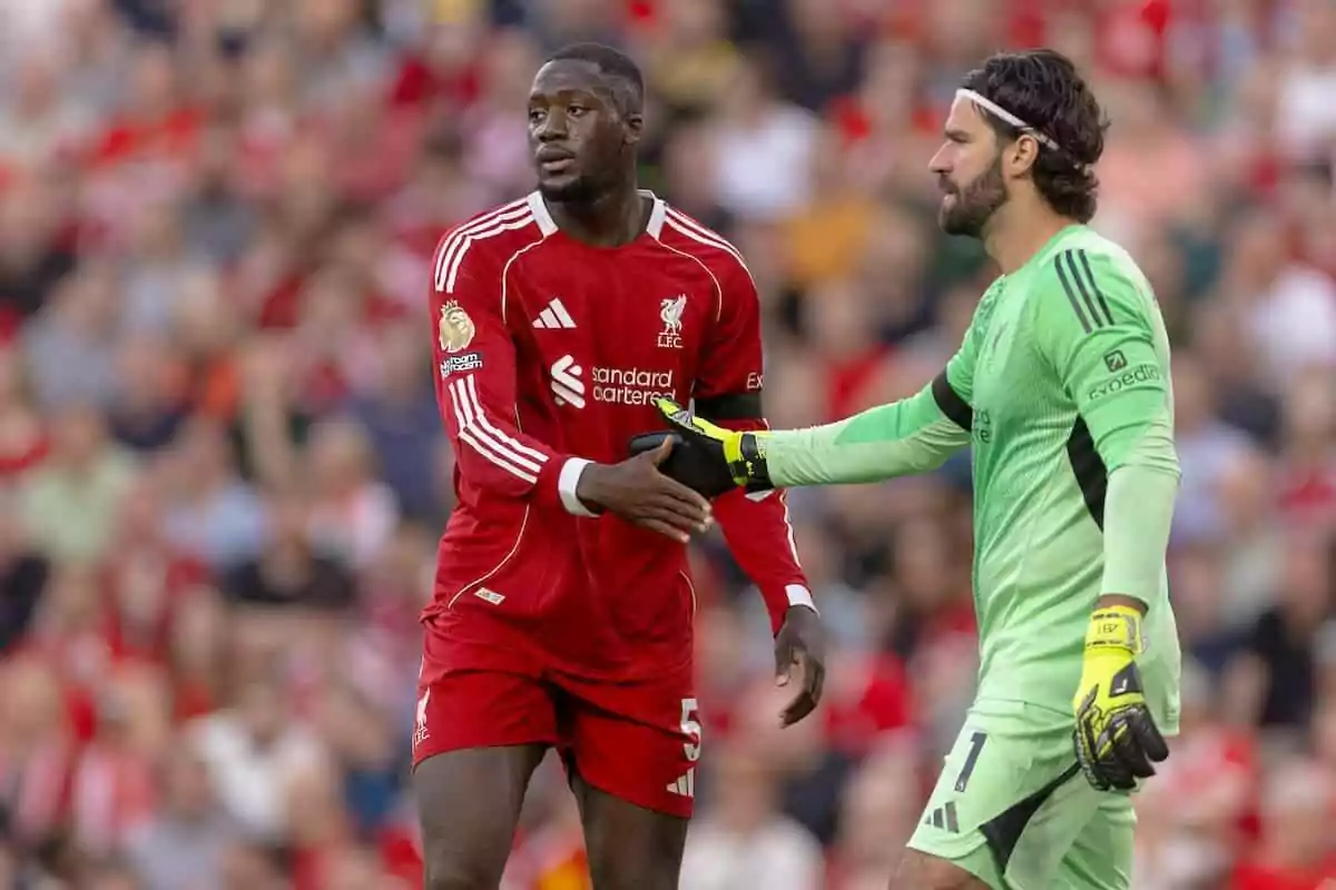 Dos jugadores del Liverpool en el campo se dan la mano durante un partido Dos jugadores del Liverpool en el campo se dan la mano durante un partido