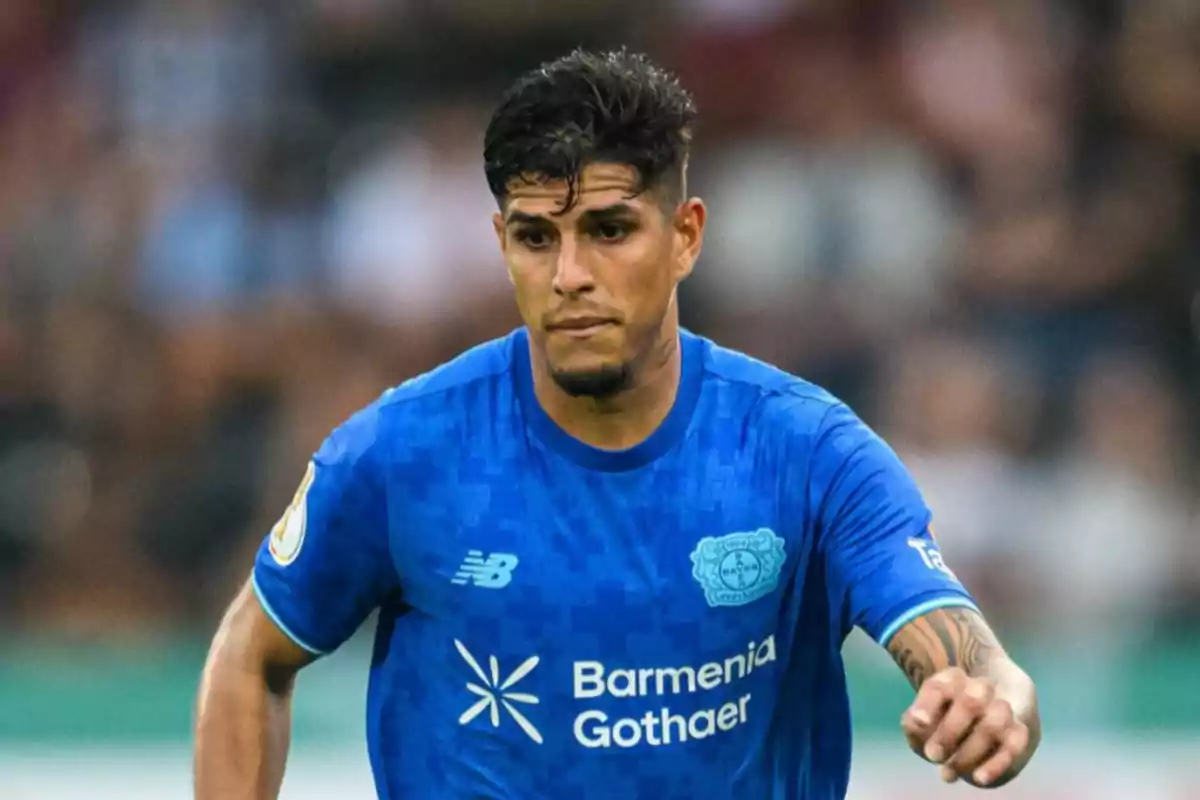Soccer player in a blue Bayer Leverkusen uniform during a match Soccer player in a blue Bayer Leverkusen uniform during a match