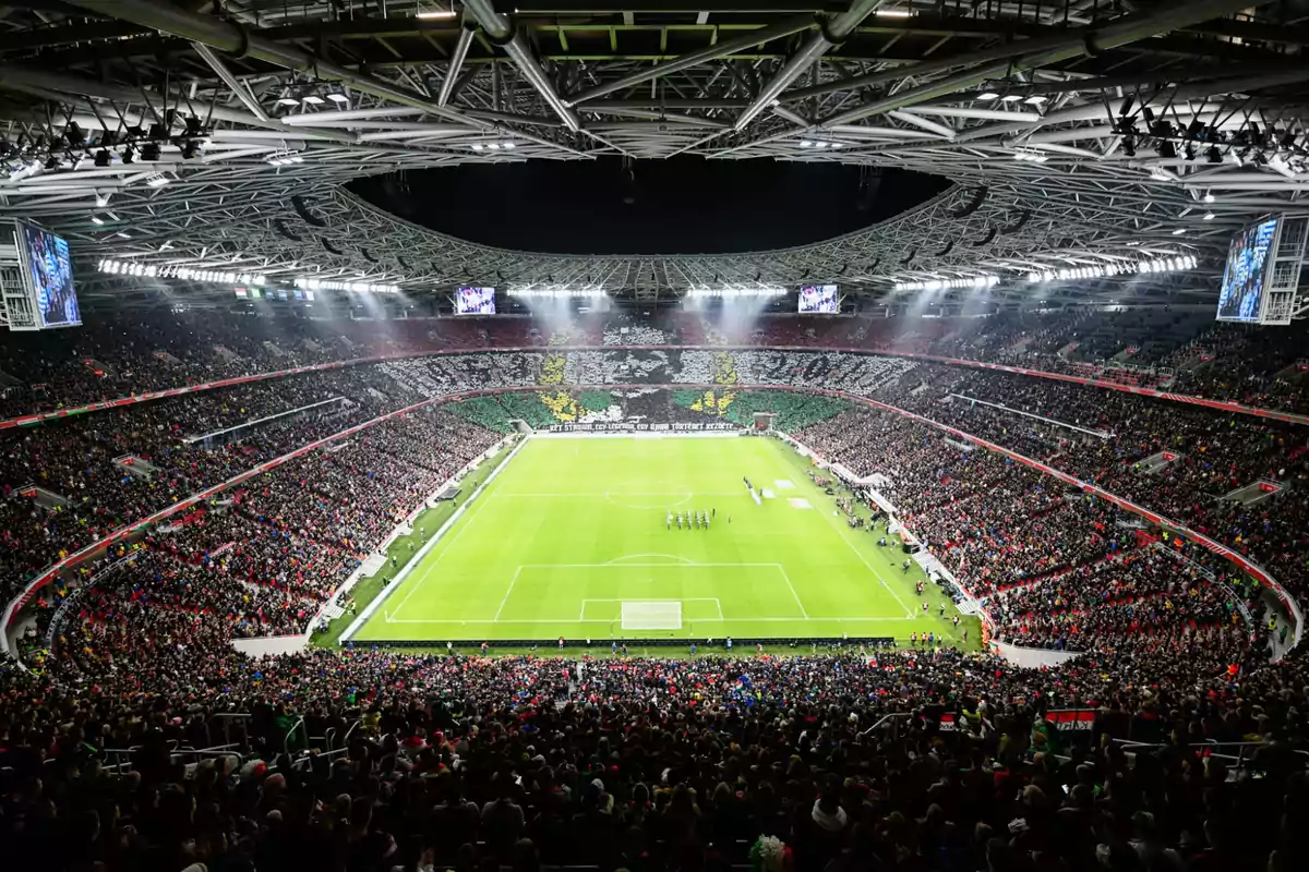 Soccer stadium packed with fans during a night match with an impressive choreography in the stands Soccer stadium packed with fans during a night match with an impressive choreography in the stands