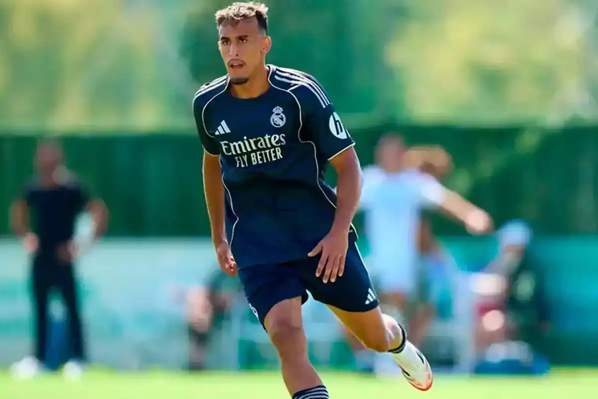 Jugador de fútbol con uniforme azul marino del Real Madrid corriendo en un campo de entrenamiento durante el día Jugador de fútbol con uniforme azul marino del Real Madrid corriendo en un campo de entrenamiento durante el día