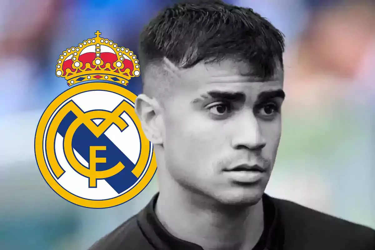 Un futbolista con expresión seria aparece en primer plano junto al escudo del Real Madrid sobre un fondo desenfocado.