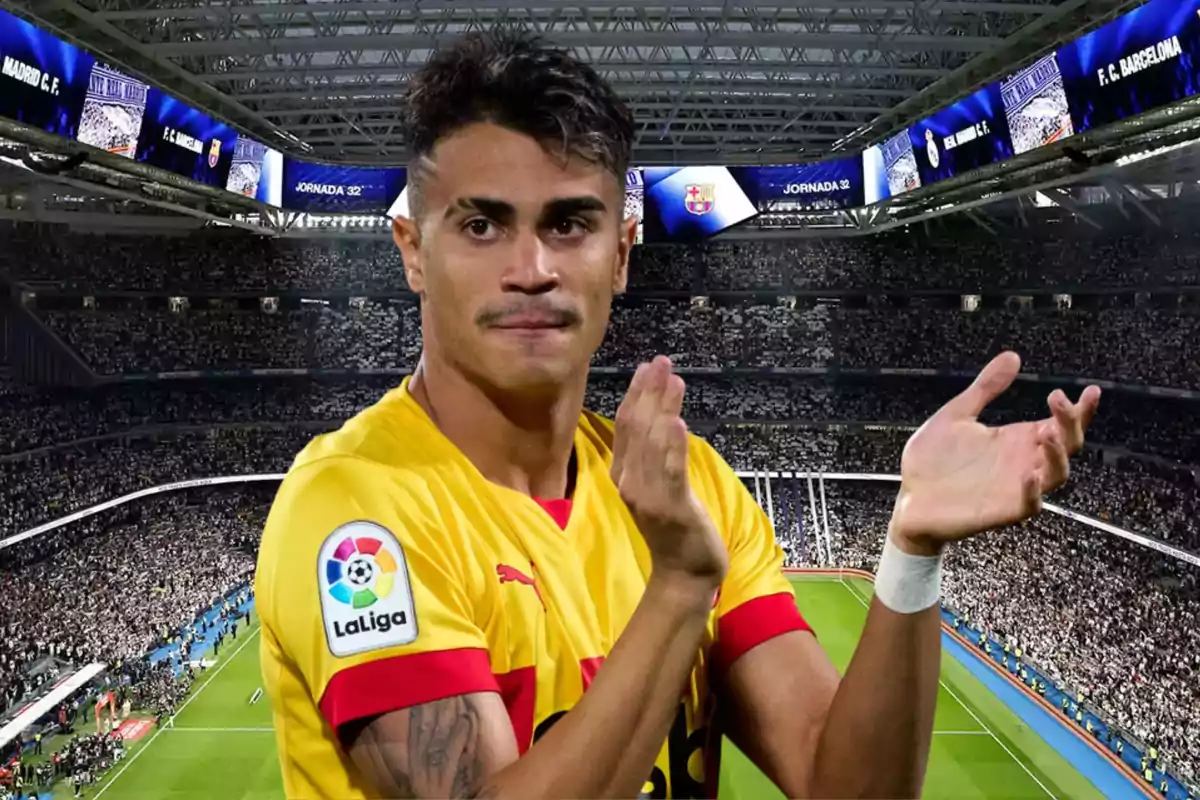 Soccer player in a yellow uniform applauding in a packed stadium during a LaLiga match