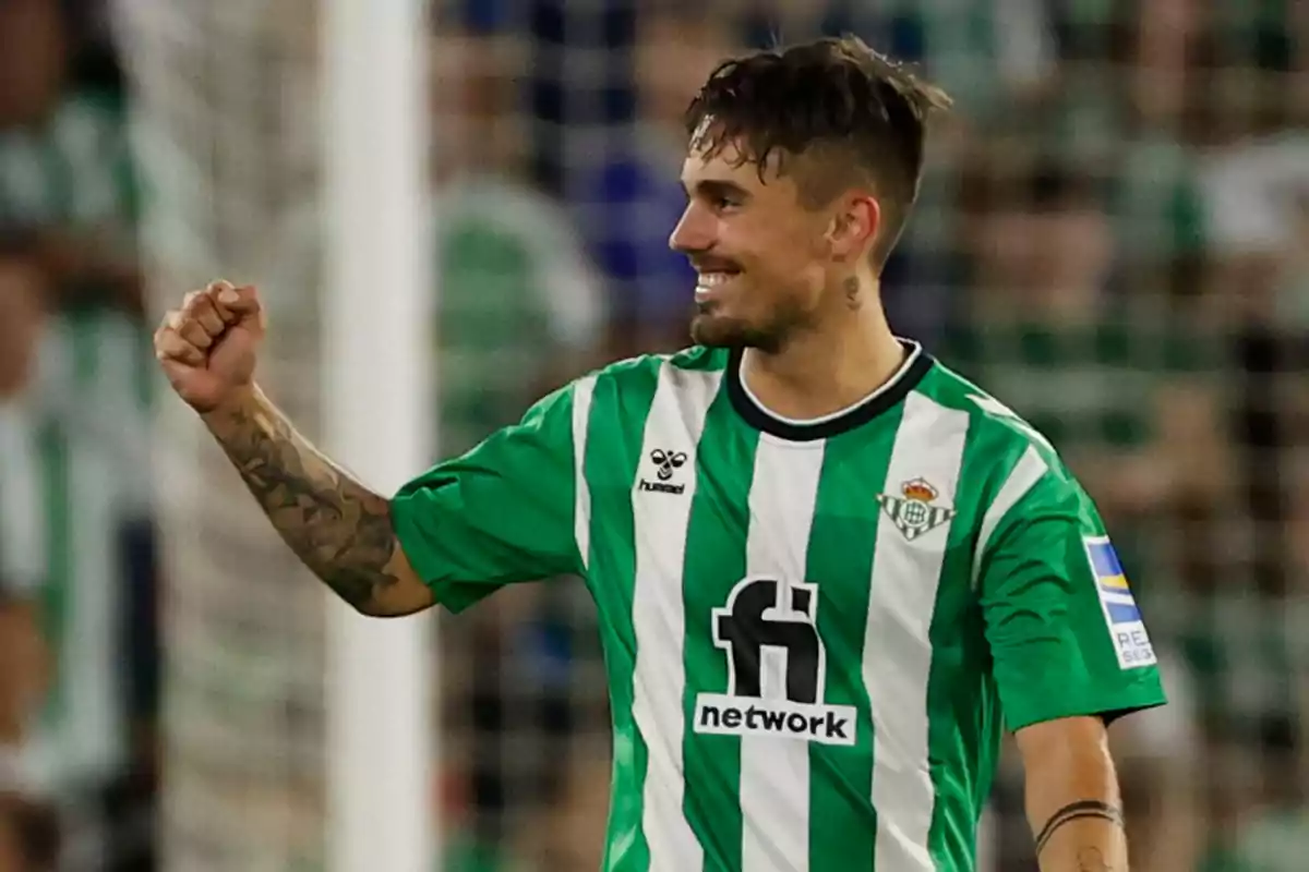 Futbolista del Real Betis celebrando en el campo con el uniforme verde y blanco Futbolista del Real Betis celebrando en el campo con el uniforme verde y blanco