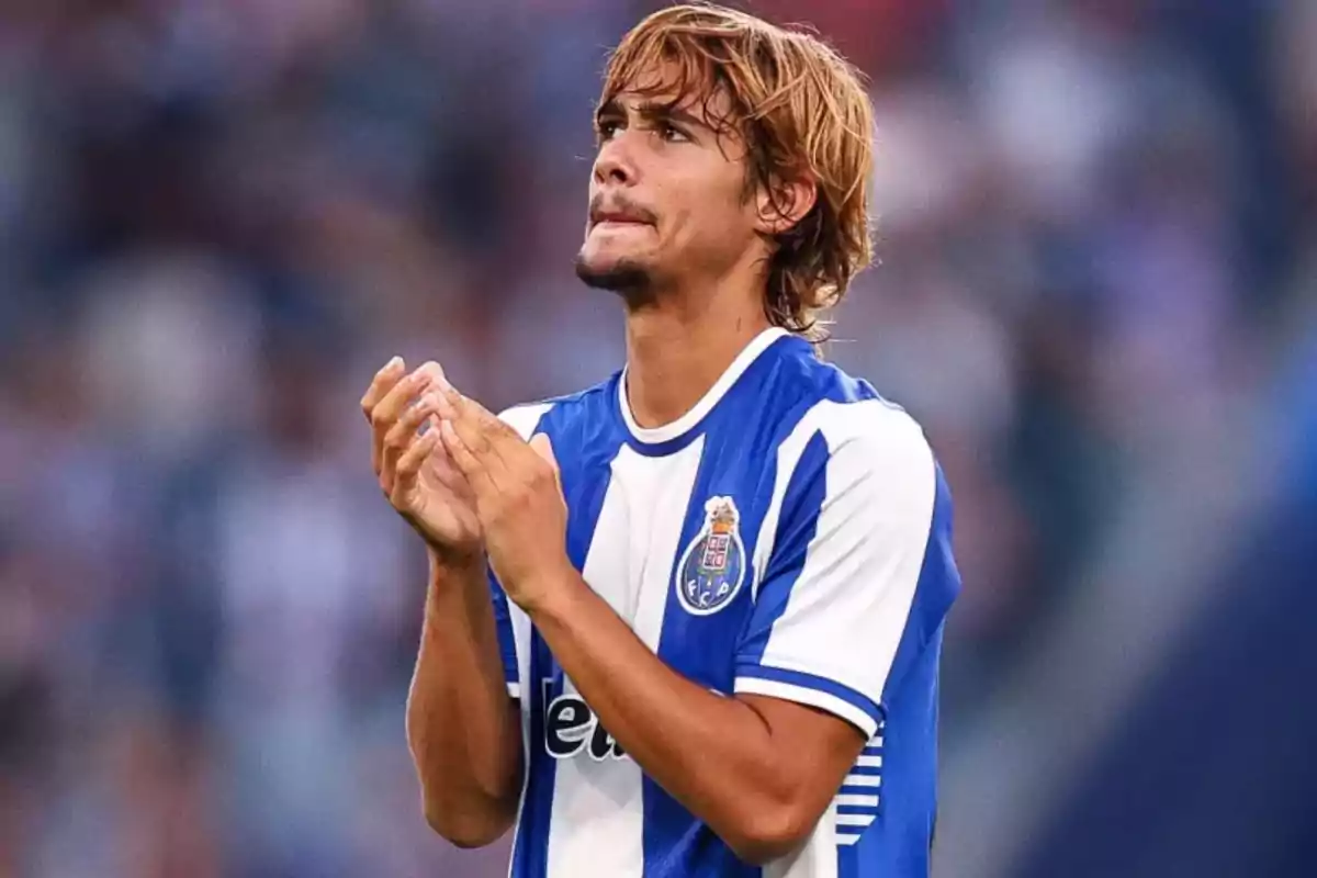 Soccer player wearing FC Porto’s blue and white uniform applauding on the field Soccer player wearing FC Porto’s blue and white uniform applauding on the field