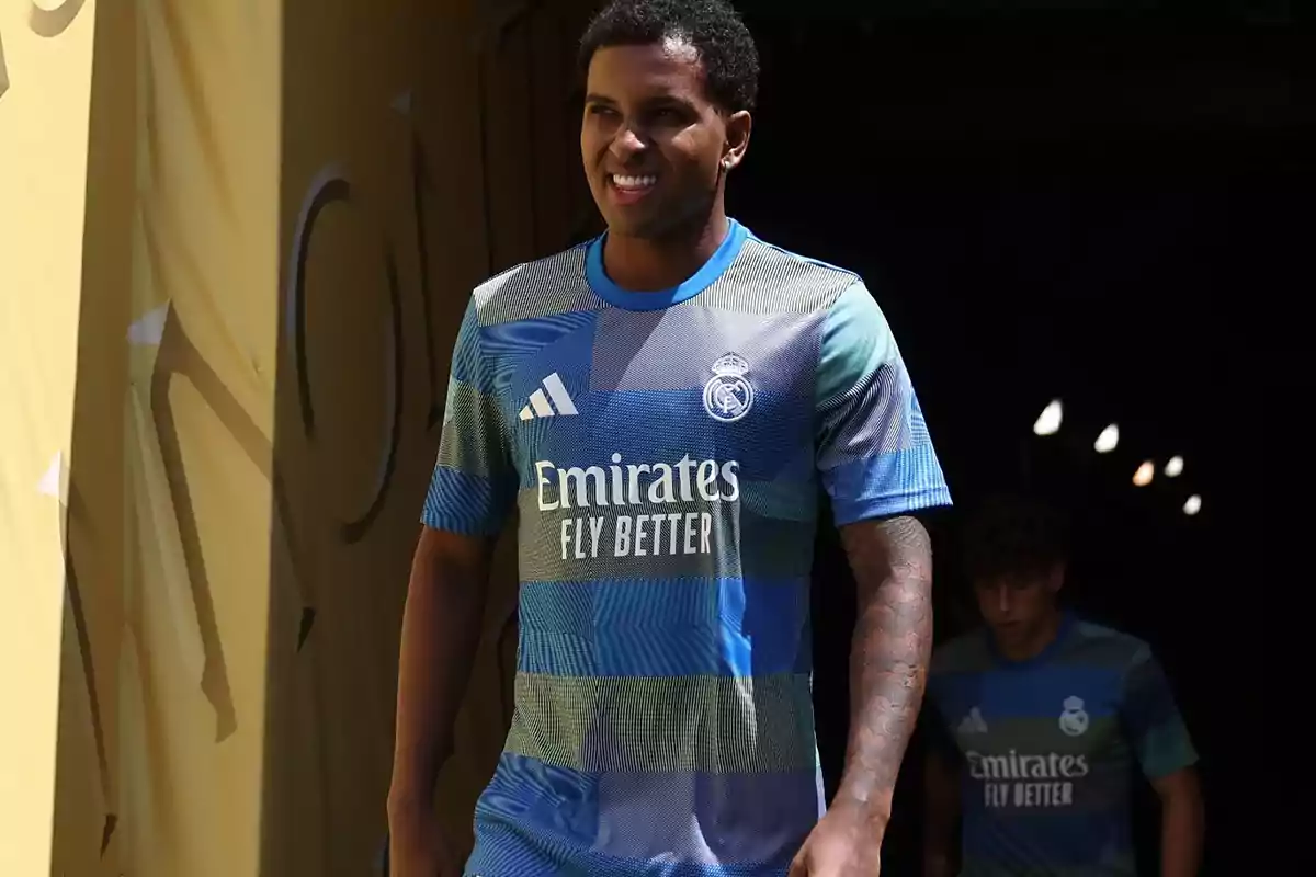 Jugador del Real Madrid con uniforme alternativo azul y verde saliendo de un túnel sonriente Jugador del Real Madrid con uniforme alternativo azul y verde saliendo de un túnel sonriente