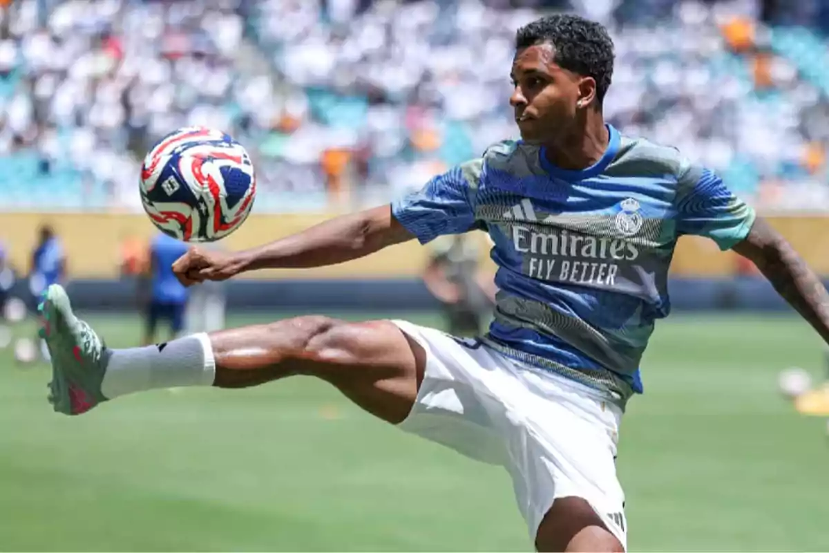 Soccer player in Real Madrid training kit controls the ball in the air during a warm-up on the field
