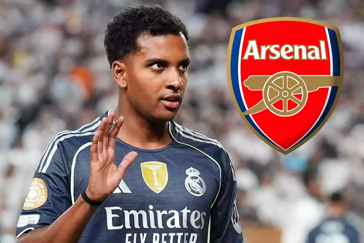Futbolista con uniforme del Real Madrid alzando la mano y el escudo del Arsenal al fondo