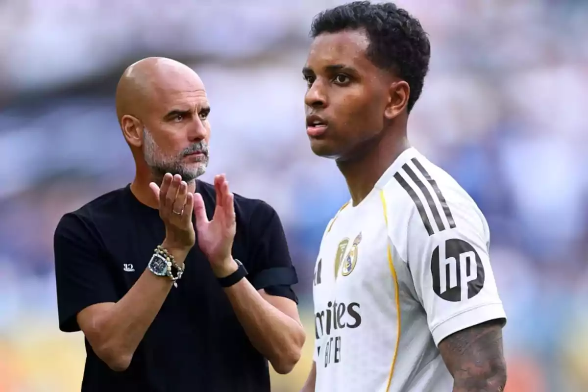 A coach applauds while a Real Madrid player in a white uniform looks ahead in a stadium.