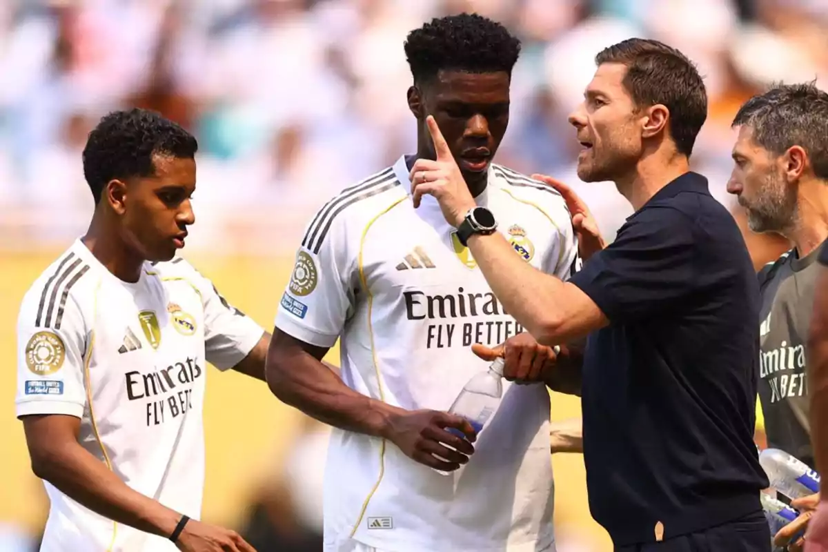 Entrenador da indicaciones a dos jugadores del Real Madrid durante un partido mientras otro miembro del cuerpo técnico observa Entrenador da indicaciones a dos jugadores del Real Madrid durante un partido mientras otro miembro del cuerpo técnico observa
