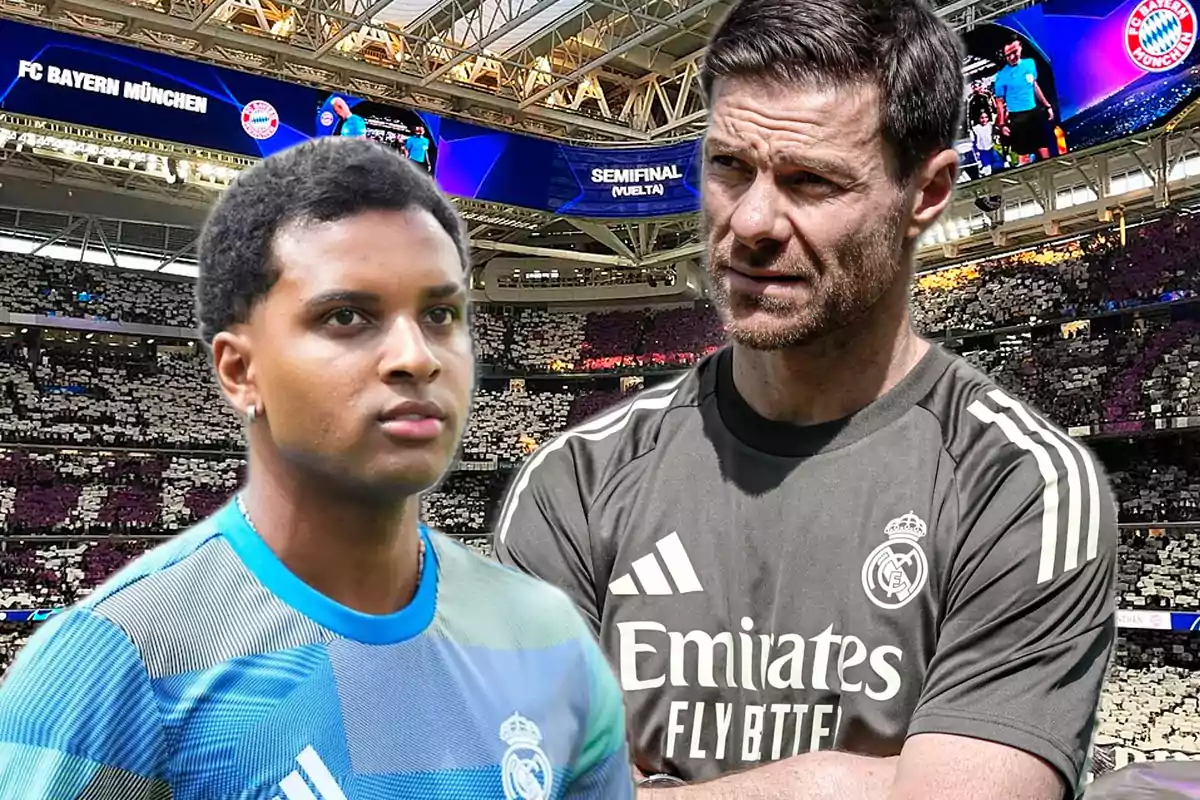Dos personas con uniformes del Real Madrid están en un estadio lleno de aficionados y en el fondo se observa un letrero que dice FC Bayern München y Semifinal Vuelta