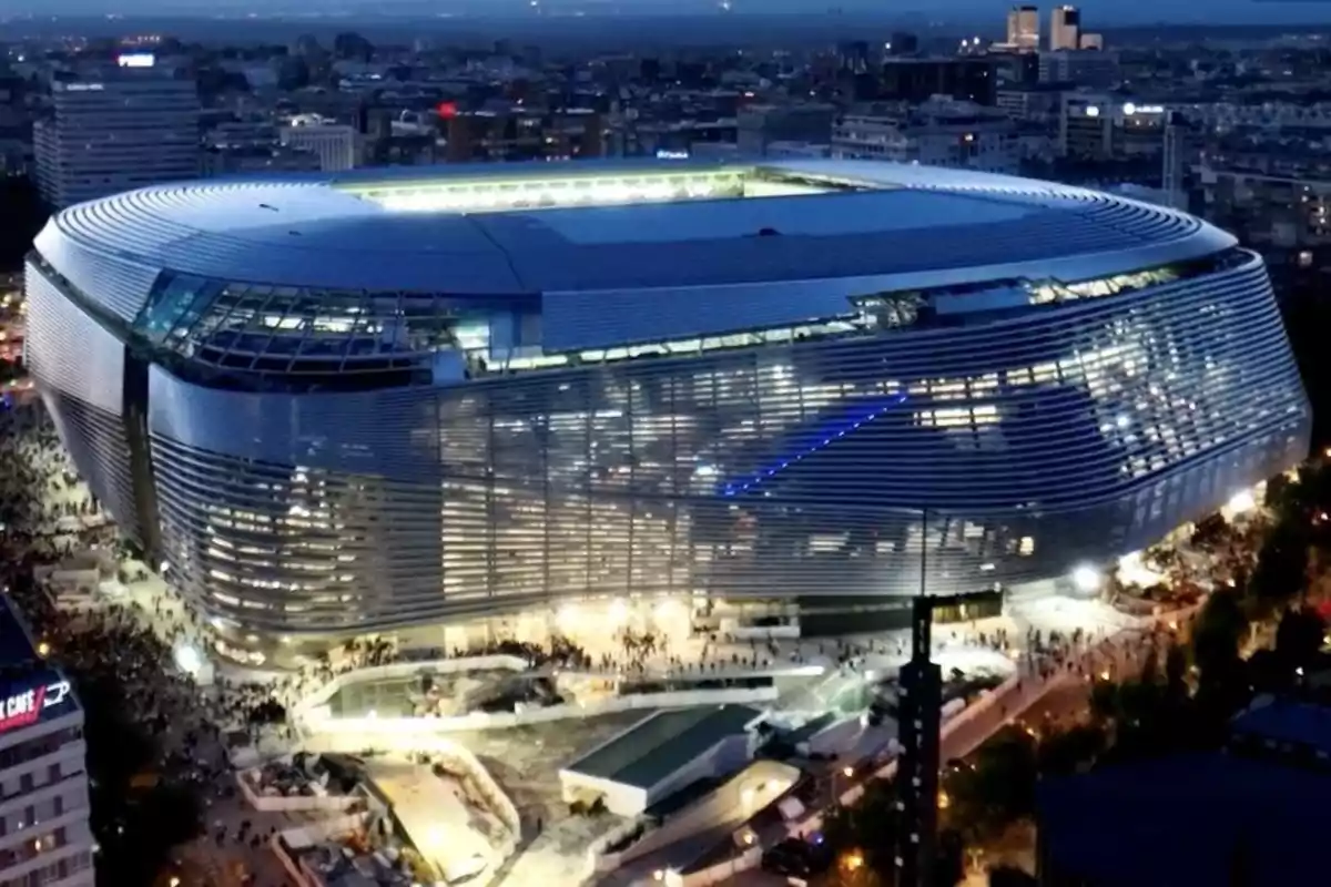 Night view of Santiago Bernabéu Stadium illuminated and surrounded by people in the city of Madrid
