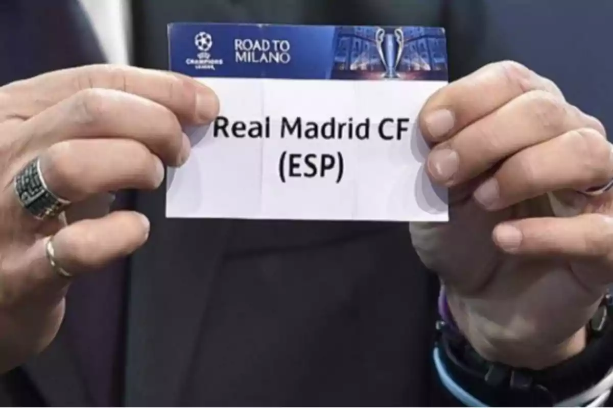 Hands holding a paper with the name Real Madrid CF during a Champions League draw.
