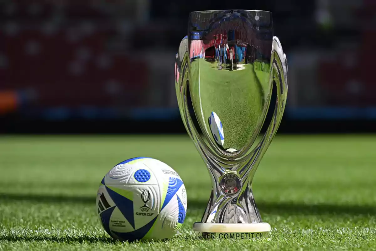 UEFA Super Cup trophy next to an official ball on the stadium grass