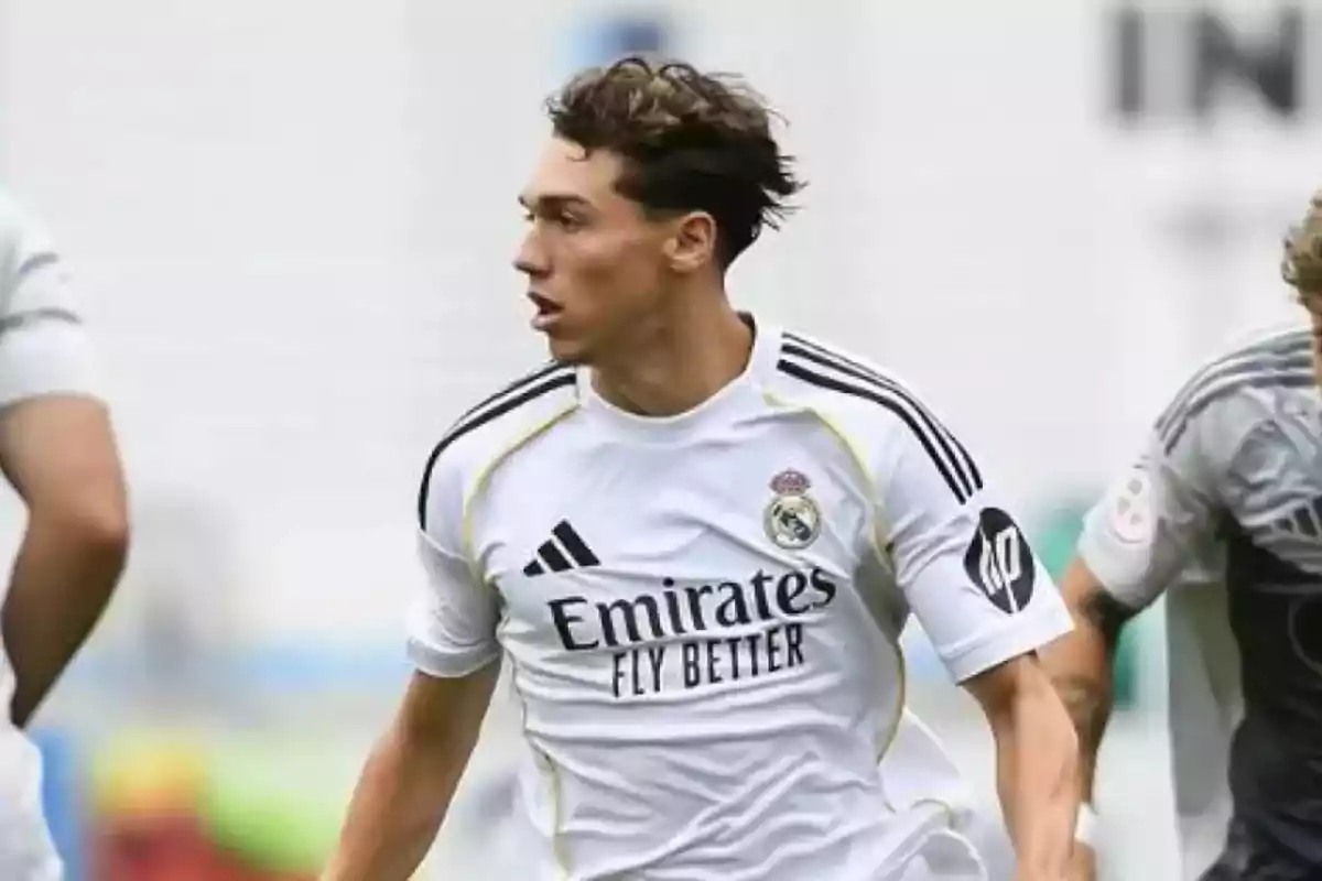 Jugador de fútbol con uniforme blanco del Real Madrid en acción durante un partido Jugador de fútbol con uniforme blanco del Real Madrid en acción durante un partido