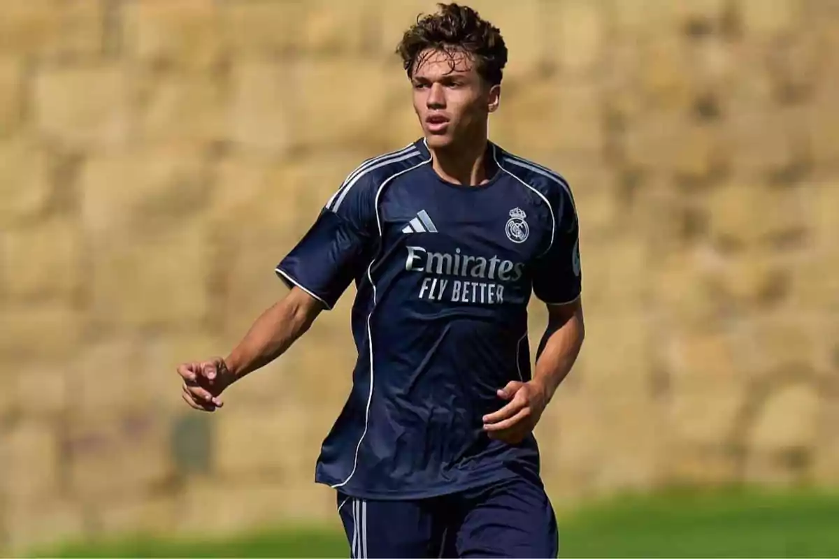 Young player in a navy blue Real Madrid uniform in action during an outdoor match Young player in a navy blue Real Madrid uniform in action during an outdoor match