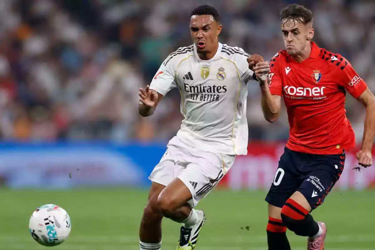 Two players compete for the ball during a match, one wearing a white uniform and the other wearing a red uniform. Two players compete for the ball during a match, one wearing a white uniform and the other wearing a red uniform.