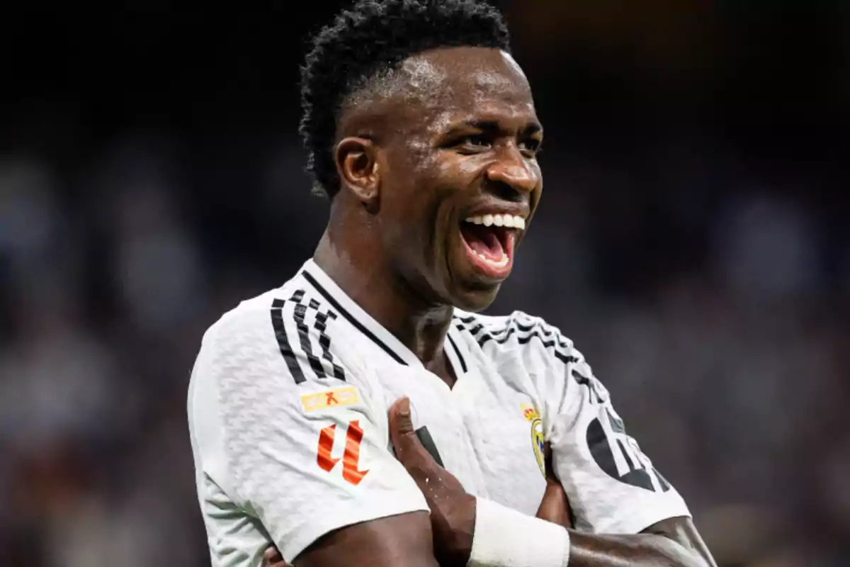 Futbolista celebrando un gol con los brazos cruzados y una gran sonrisa durante un partido Futbolista celebrando un gol con los brazos cruzados y una gran sonrisa durante un partido