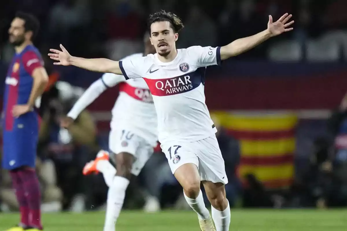 PSG player celebrating a goal with arms outstretched during a match against Barcelona PSG player celebrating a goal with arms outstretched during a match against Barcelona