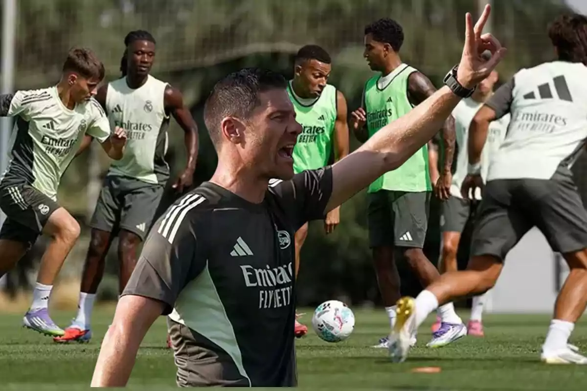 Coach giving instructions during a soccer training session with several players on the field wearing Real Madrid training uniforms