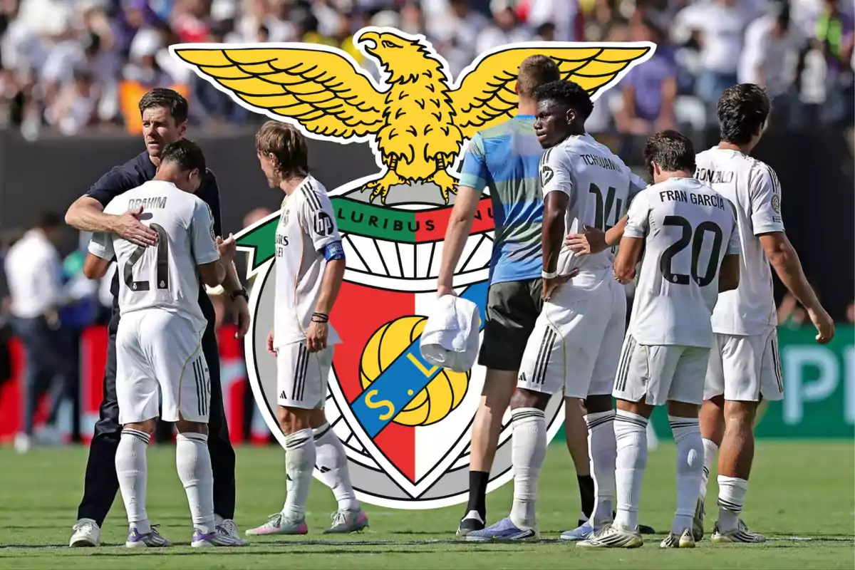Real Madrid players on the field with the Benfica crest in the background