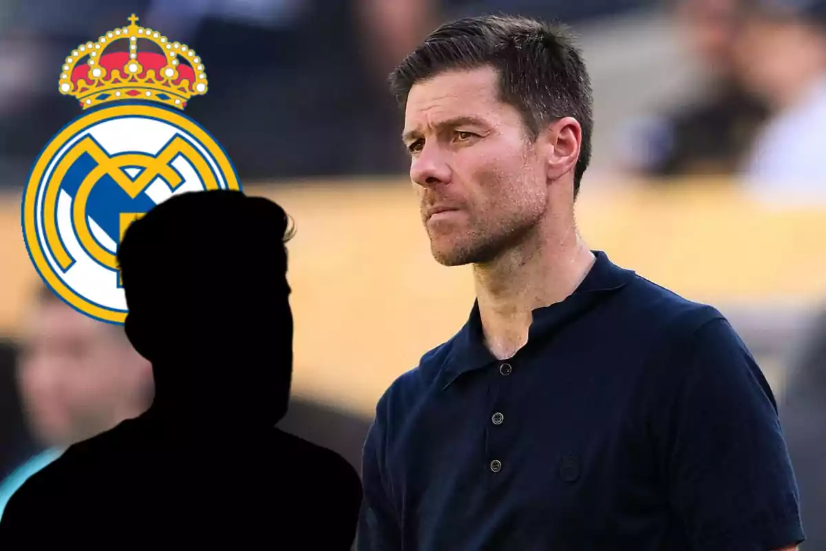 Short-haired, bearded man looking forward with the Real Madrid crest and the black silhouette of a person in the foreground