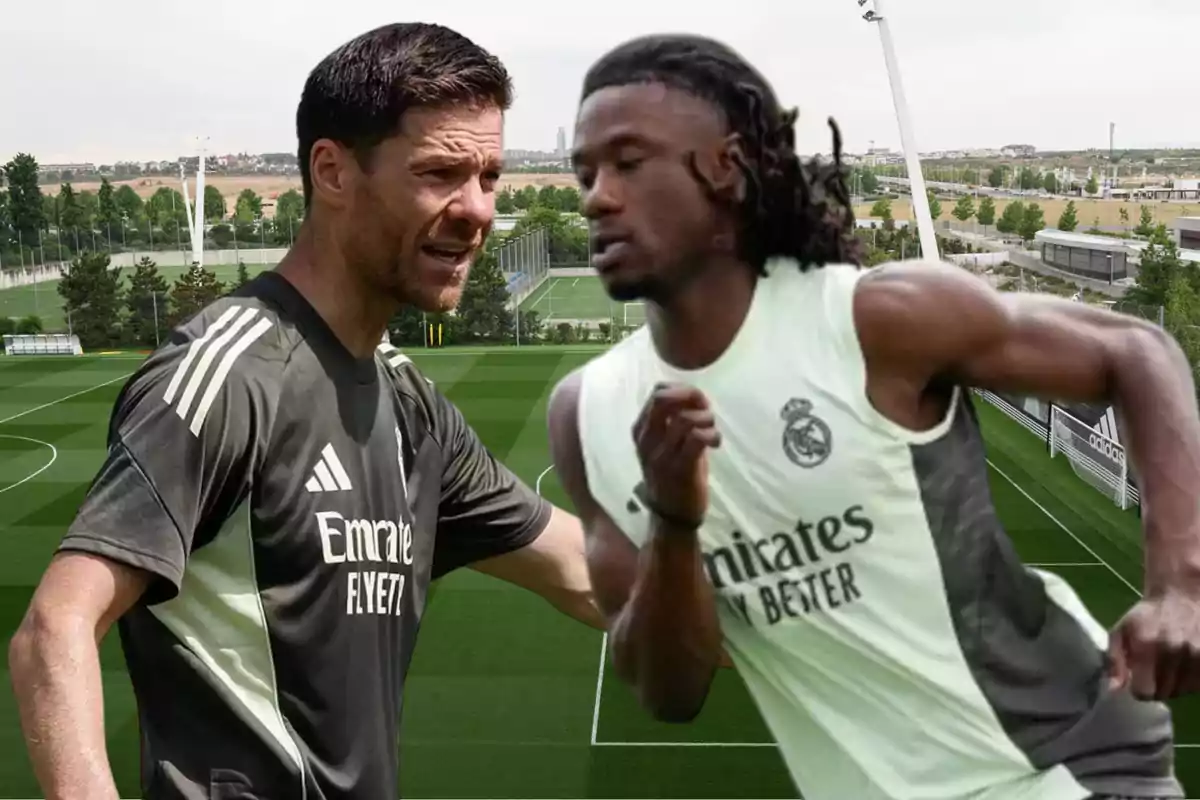 Two Real Madrid players training on a soccer field, one of them running and the other giving instructions.
