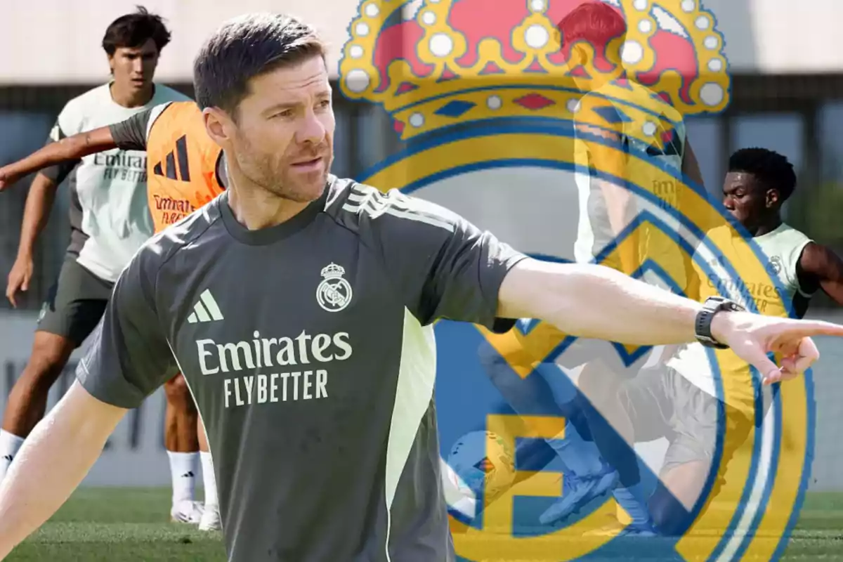 Real Madrid soccer coach giving instructions during a training session with players and the club’s crest in the background
